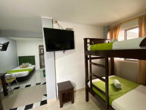 a room with two bunk beds and a flat screen tv at Hotel El Deportista in Medellín