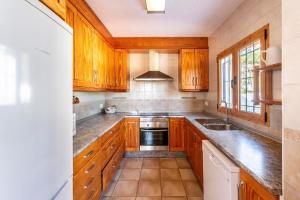 a kitchen with wooden cabinets and a sink at Casa Aalaya Ibiza Mediterranean Retreat in Illes Balears