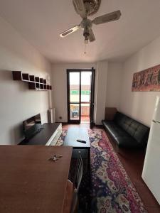 Una sala de estar con un sofá y un ventilador de techo. en Rose 9 Palace, en Brescia
