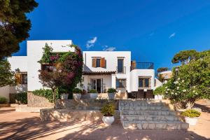 una casa blanca con escaleras delante en Casa Aalaya: Ibiza Mediterranean Retreat, en Illes Balears