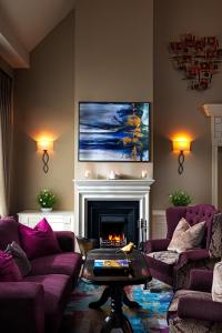 a living room with purple couches and a fireplace at Longcourt House Hotel in Newcastle West