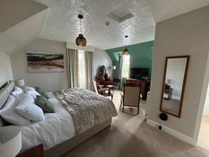 a bedroom with a bed and a desk and a mirror at Glen Lyon Lodge Bed and Breakfast in Nairn +21 photos