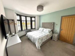 a bedroom with a bed and a dresser and windows at No.3 in Cardiff