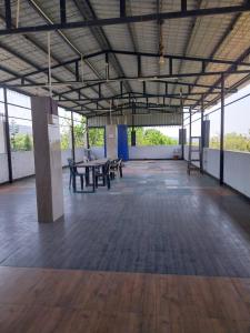 an empty room with tables and benches in a building at New green hotel in Yelagiri