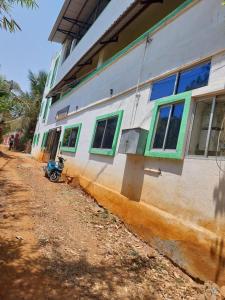 a motorcycle parked next to a building with windows at New green hotel in Yelagiri