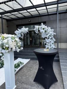 uma mesa preta com flores brancas num edifício em Black Tulip Hotel em Dej