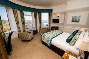 a hotel room with a bed and windows at Raven Hall Hotel in Ravenscar