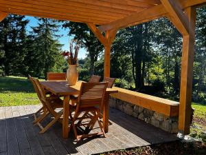 - une table en bois avec des chaises et un vase sur la terrasse dans l'établissement Vacation house Polane, à Delnice