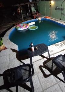 a table and chairs next to a swimming pool at Aloha hospedaje in Puerto Iguazú