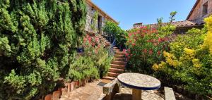 un callejón con una mesa de piedra y escaleras con flores en Meublés de Tourisme Casa Erbaggio, en Sartène