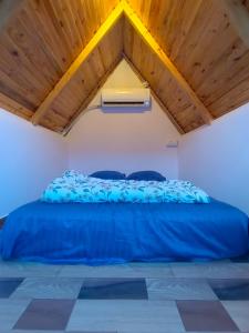 a bed in a room with a wooden ceiling at Starlit premium camps in Mahabalipuram