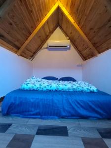 a large blue bed in a room with a wooden ceiling at Starlit premium camps in Mahabalipuram