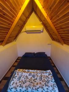 a bed in a small room with a wooden ceiling at Starlit premium camps in Mahabalipuram