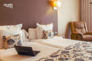 una habitación de hotel con un ordenador portátil en una cama en Num Hotel en Salou