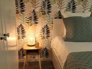 sypialnia z łóżkiem i stołem z lampką w obiekcie Le Grand Cerf 