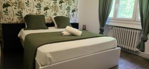 sypialnia z łóżkiem z zieloną i białą pościelą w obiekcie Le Grand Cerf 