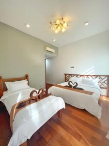 a bedroom with two beds and a chandelier at Ezyhouz Homestay #The Loft Imago City #Luxury Pool Garden View in Kota Kinabalu