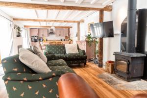 a living room with a couch and a stove at West Town Barn in Exeter