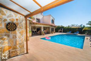 a swimming pool in a yard with a stone house at Villa Hugo 11 by Abahana Villas in Benissa