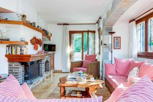 sala de estar con muebles de color rosa y chimenea en La Torreta, en Palafrugell