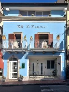 un edificio azul con 2 balcones en una calle en La Piazzetta, en Giardini Naxos
