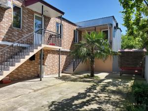 a brick house with stairs and a palm tree at N2 House in Chakvi