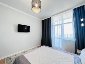 1 dormitorio con cama y ventana grande en ЖК "Бухар жырау эксклюзив" Люксовые апартаменты, en Astana