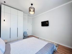 um quarto com uma cama e uma televisão na parede em ЖК "Бухар жырау эксклюзив" Люксовые апартаменты em Astana