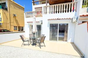 a patio with a table and chairs and a balcony at Beach Love BeachFront Apartment in Pyla