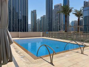 a swimming pool on the roof of a building with tall buildings at Frank Porter - Forte Tower 1 in Dubai
