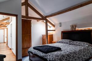 um quarto com uma cama num quarto com tectos em madeira em West Town Barn em Exeter