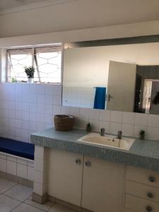 y baño con lavabo y espejo. en Choice Guesthouse and Backpackers en Bulawayo
