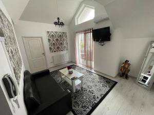 a living room with a black couch and a table at Sara Apartament in Lugoj