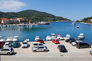 a bunch of cars parked in a parking lot next to a harbor at Sunshine Apartment Doda in Vela Luka