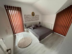 a bedroom with a bed and a large window at Sara Apartament in Lugoj