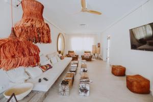 Apartamentos Sunset Oasis Ibiza - Only Adults في خليج سان أنتوني: غرفة معيشة مع أريكة بيضاء وطاولة