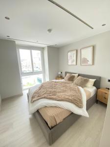 a white bedroom with a large bed with pillows at Deluxe Marina View Seafront Gibraltar Stay in Gibraltar +47 photos