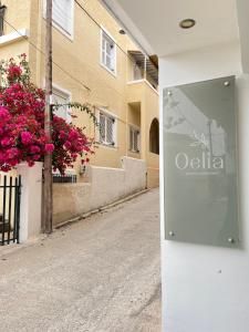una señal en el lado de un edificio con flores en Oelia Rooms & Apartments en Agia Marina Aegina