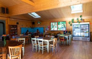 ein Restaurant mit Holzböden, Tischen und Stühlen in der Unterkunft THE TENT - Youth Only - Buchung leider nur bis 30 Jahre möglich! in München