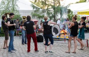 eine Gruppe von Menschen, die mit Instrumenten um ein Feuer stehen in der Unterkunft THE TENT - Youth Only - Buchung leider nur bis 30 Jahre möglich! in München