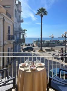 un tavolo su un balcone con vista sull'oceano di La Piazzetta a Giardini Naxos