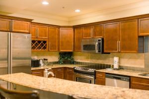 a kitchen with wooden cabinets and stainless steel appliances at Harborwalk Village Two Bedroom Vacation Rental in Destin