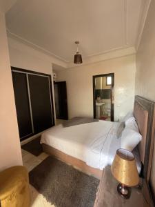 um quarto com uma grande cama branca e um espelho em Dar Yasmine em Marrakech