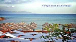 a beach with many straw umbrellas and the ocean at Villa Nickolas in Paleo Tsifliki
