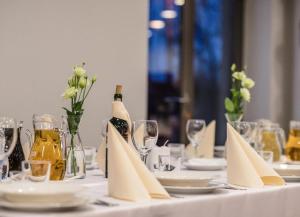 stół z białą tkaniną stołową z butelkami wina i kieliszkami w obiekcie Alibi - Sympozjum Studio w Krakowie
