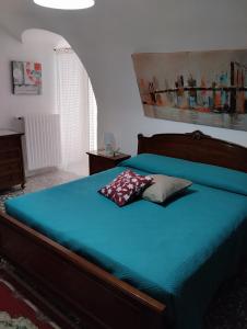 a bedroom with a bed with a blue comforter at L' Archè in Castellaneta