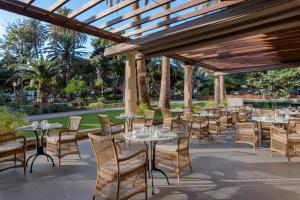 a patio with tables and chairs under a pergola at Santa Catalina, a Royal Hideaway Hotel in Las Palmas de Gran Canaria