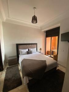 um quarto com uma cama grande e uma janela grande em Dar Yasmine em Marrakech