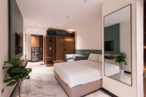 a bedroom with a white bed and a mirror at Luxe Paradise Suites Hotel Hoang Cau in Hanoi