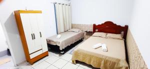 - une petite chambre avec 2 lits et un miroir dans l'établissement Flat JM, à Parauapebas